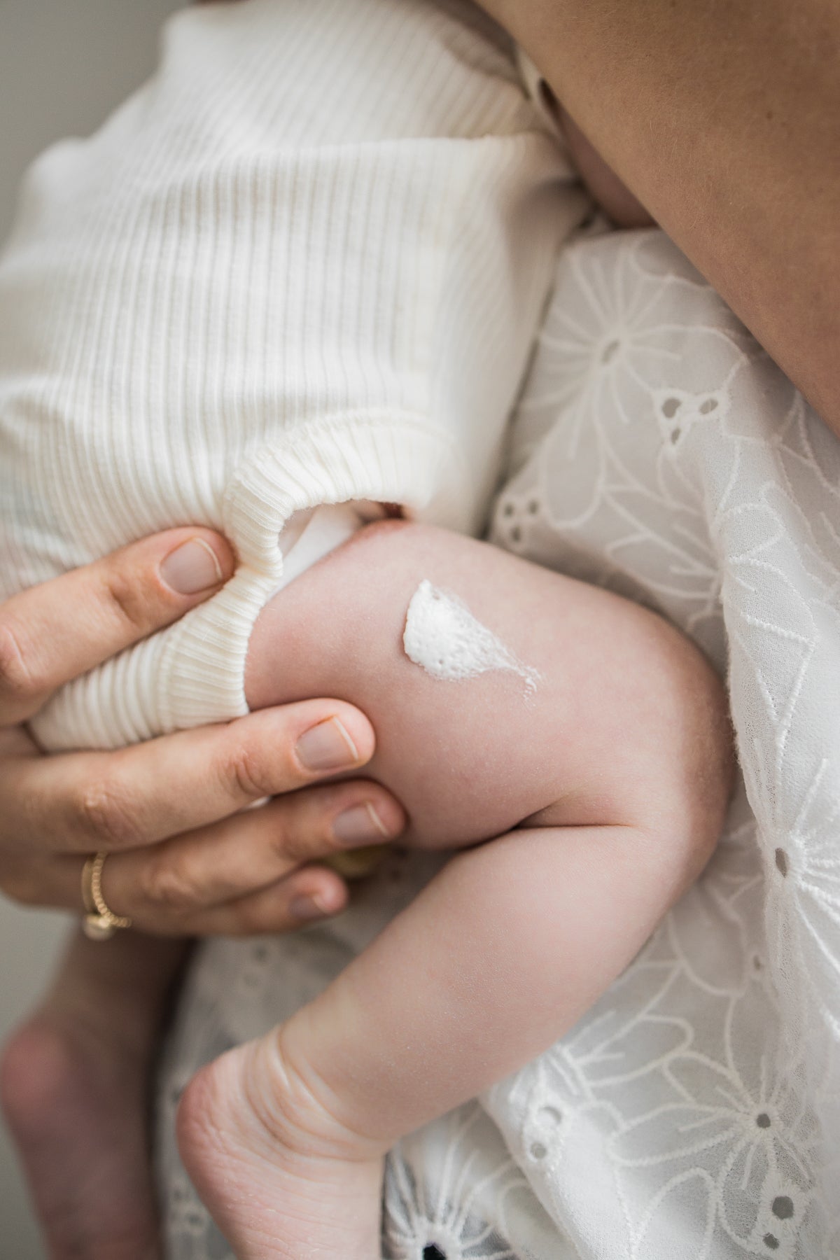 close up of a baby's thigh with OWN SKIN CO's whipped tallow baby moisturizer cream spread on leg