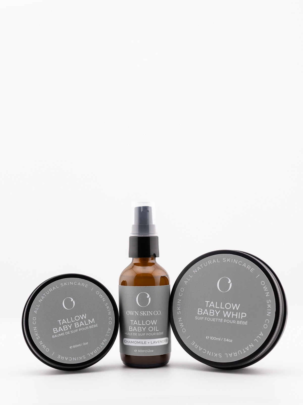 Three baby care products on a white background. A natural baby balm, baby whipped lotion and a baby oil