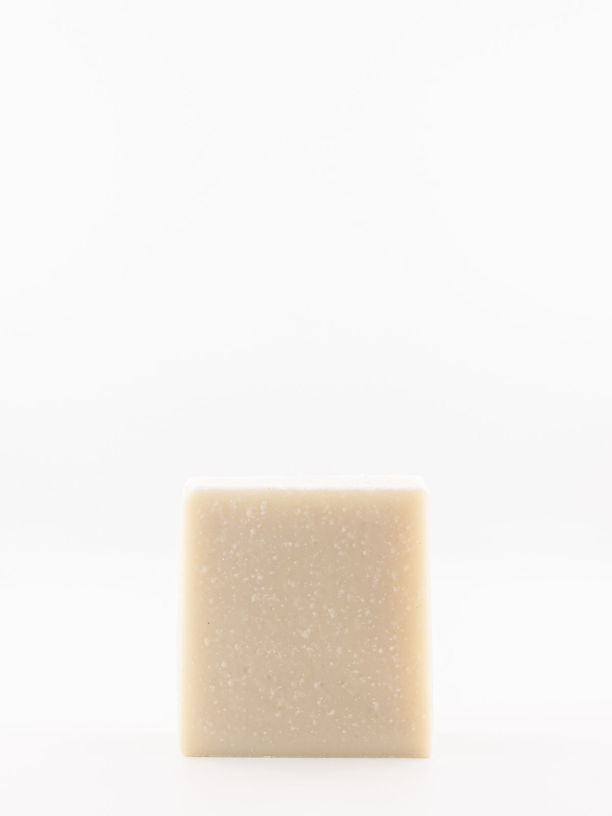 A single square bar of beef tallow eucalyptus soap with a light beige colour and fine white speckles, centred against a solid white background.