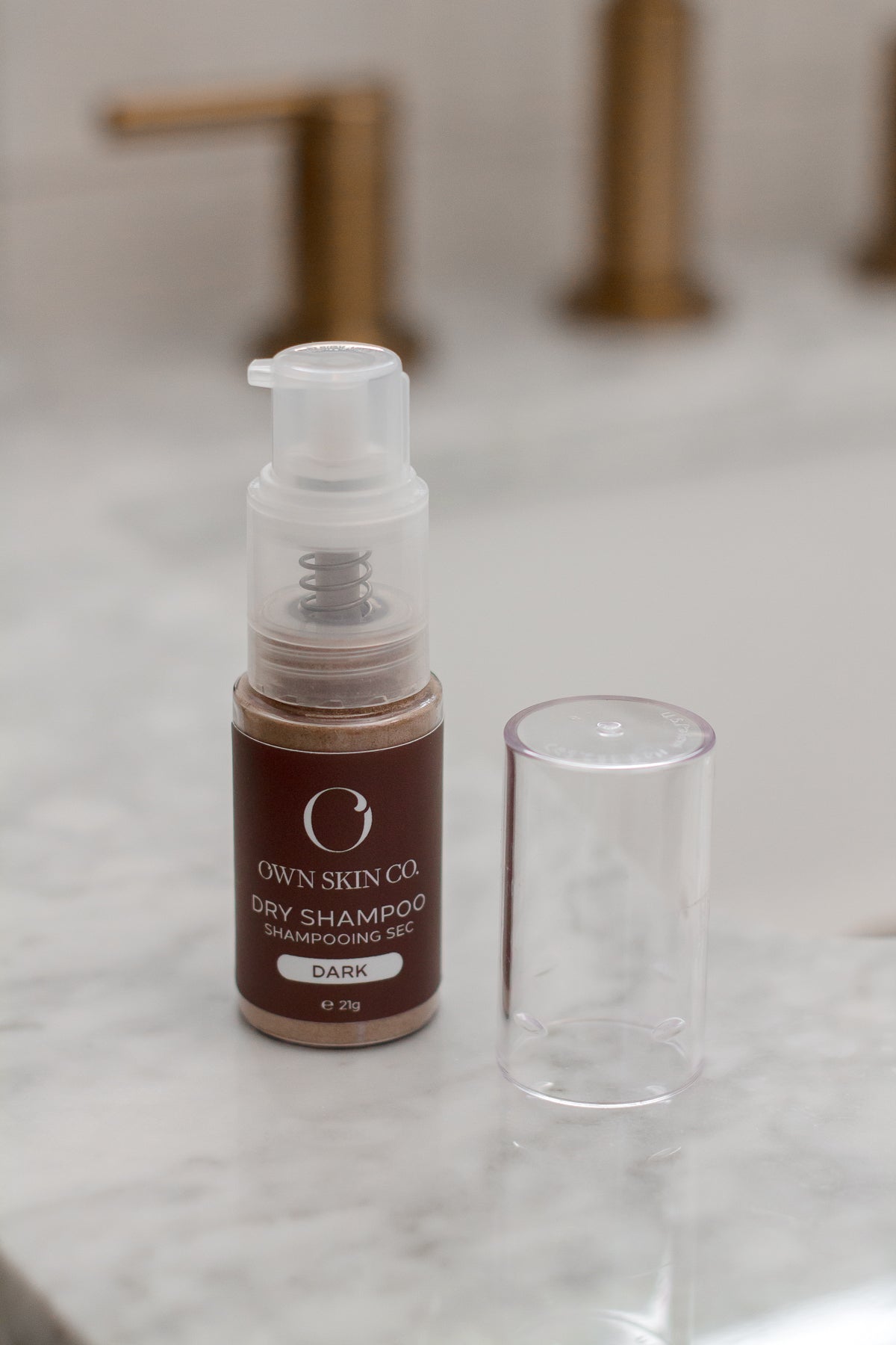 Natural Dry Shampoo Spray on White Counter with Gold Faucet in background