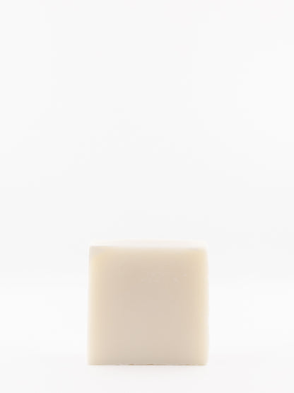 A single square bar of own skin co.'s beef tallow baby wash standing upright against a seamless white background.