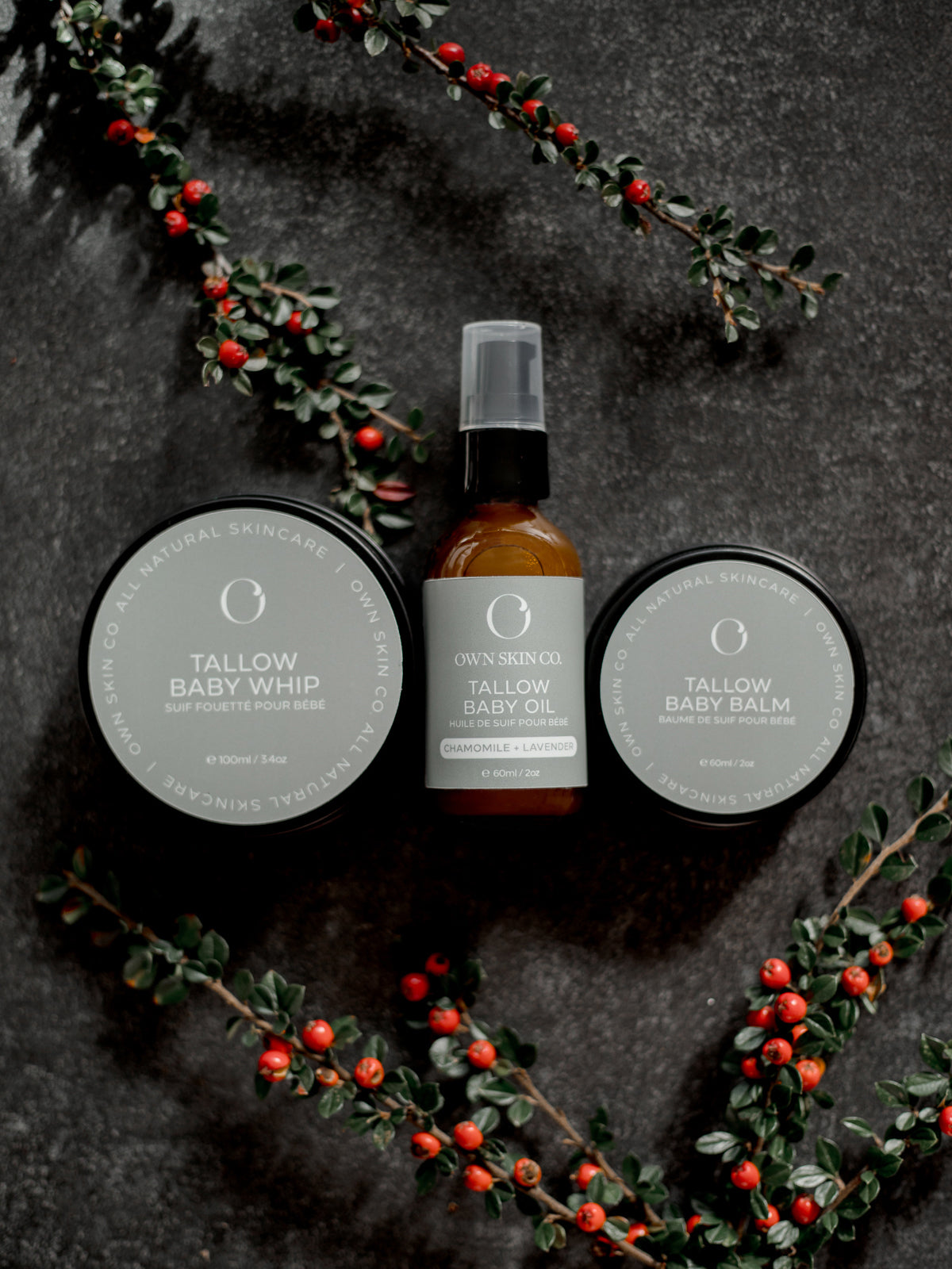 Tallow-based skincare products for babies and kids with a dark background and red berries