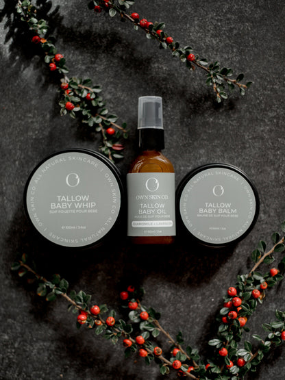Tallow-based skincare products for babies and kids with a dark background and red berries