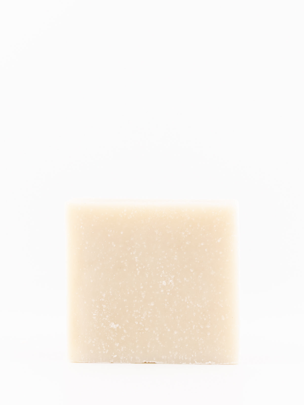 A single rectangular bar of tallow soap with a light beige, creamy texture and fine white speckles, centered against a solid white background.