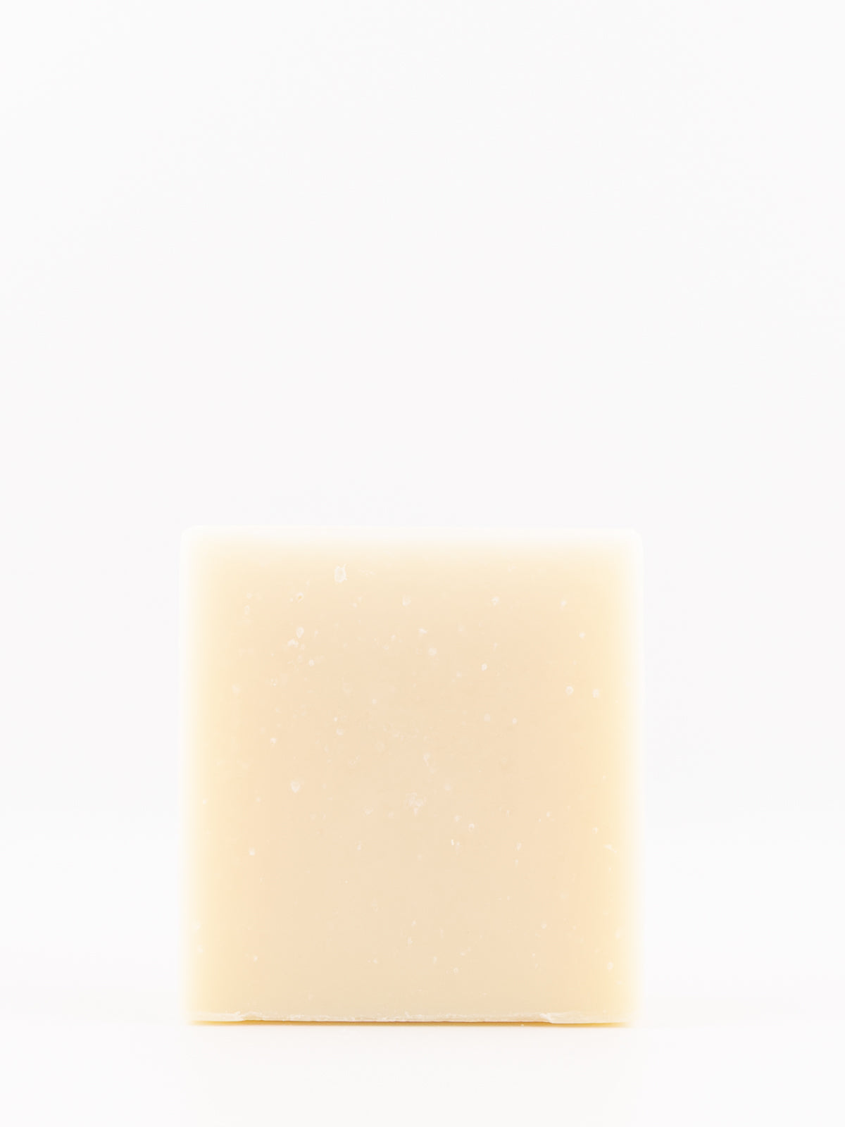 A single rectangular bar of pale cream-colored lavender soap with tiny white specks, centered on a seamless white background.