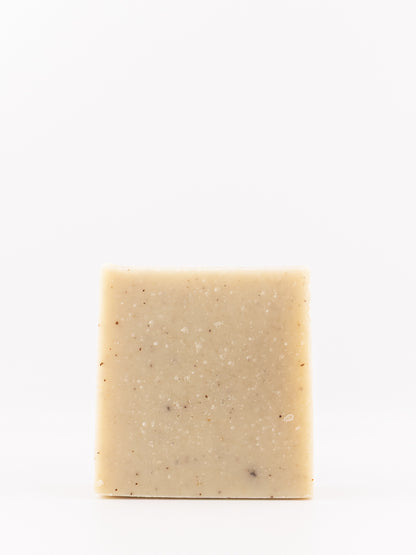 a speckled artisan handmade soap bar with little speckles in mountain breeze men's scent on a white background. 