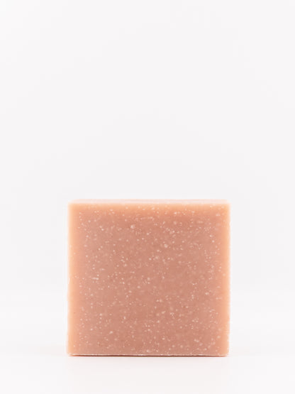 A single rectangular bar of tallow soap with a dusty rose pink coloru and fine white speckles, centered against a plain white background.