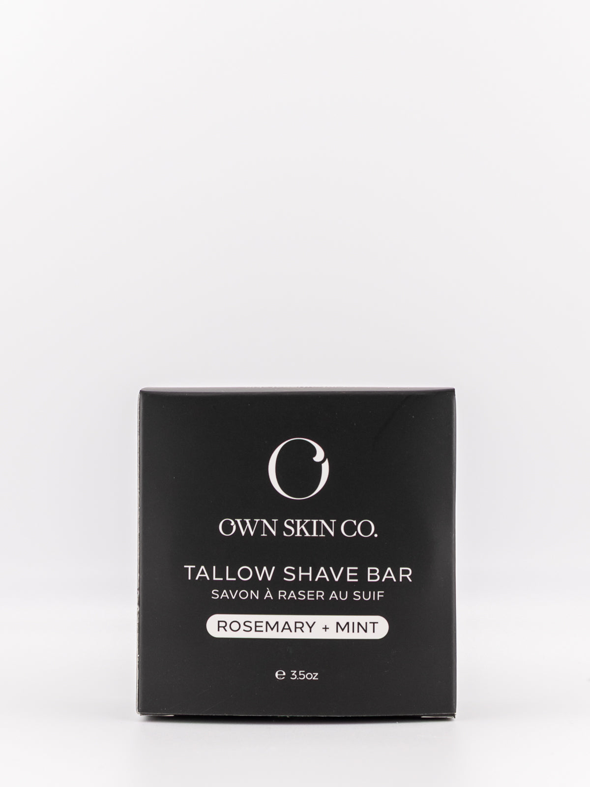 Own Skin Co. Tallow Shave Bar in a square black box with white text, labeled Rosemary + Mint, on a clean white background.