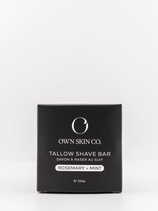 Own Skin Co. Tallow Shave Bar in a square black box with white text, labeled Rosemary + Mint, on a clean white background.