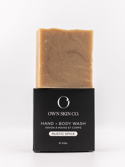 A bar of Own Skin Co. Hand & Body Wash in the Rustic Spice scent, shown with its black packaging box on a clean white background.