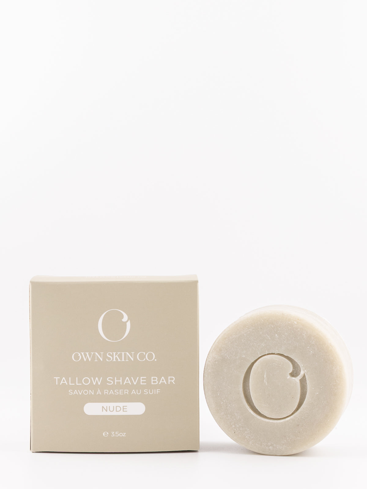 Own Skin Co. Tallow Shave Bar in 'Nude' shown next to its beige packaging box on a clean white background.