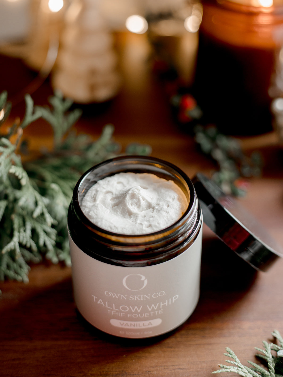 Jar of beef tallow whip on a wooden surface with decorative elements